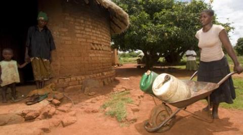 Jane Mudiiwa carries water from a local well, Zimbabwe, Macpherson photographers