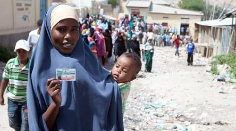 Somaliland woman holds ID card in queue to vote