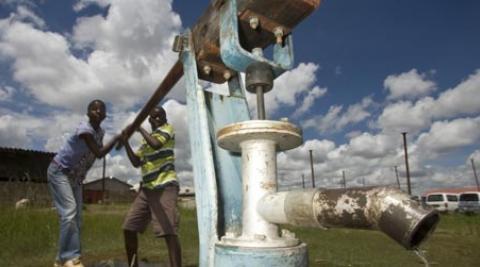 Esla Batira and Enforce Dangarembizi demonstrate how the new well and water pump