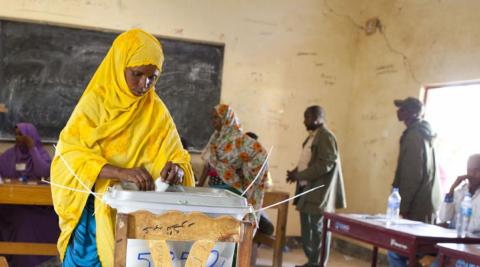 Woman places vote in ballot box, Somaliland