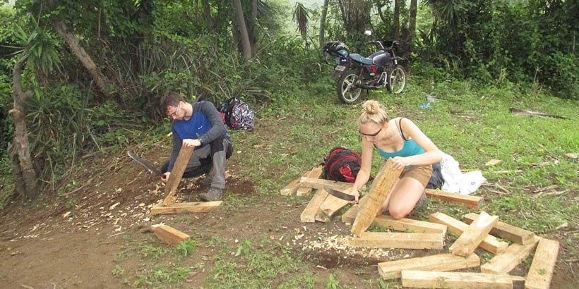 Volunteers cutting stakes with a machete